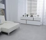 Bright and spacious living room featuring modern minimalist decor, a white sofa, and sleek furniture.